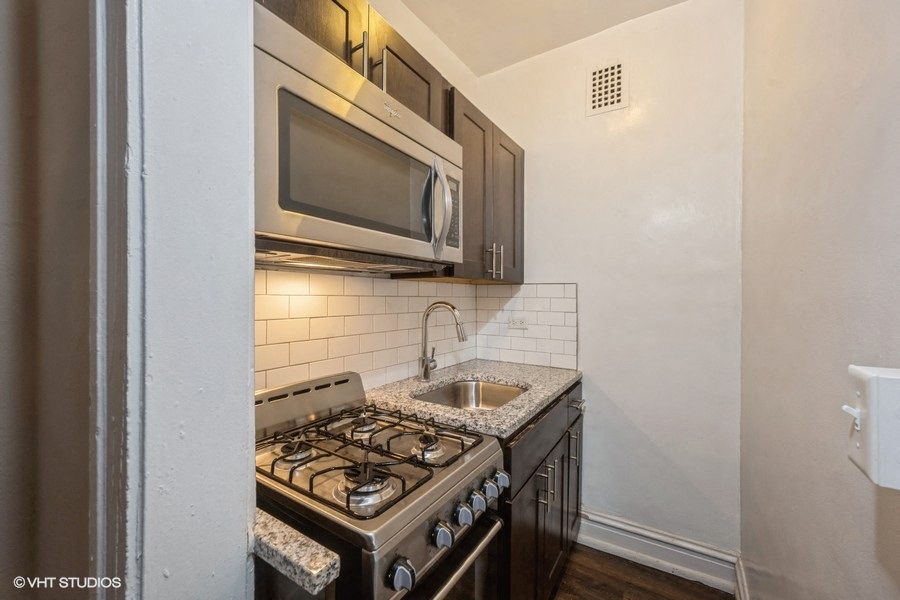 renovated studio apartment kitchen with stainless steel appliances at ivy at sylvan hyde park apartments near uchicago